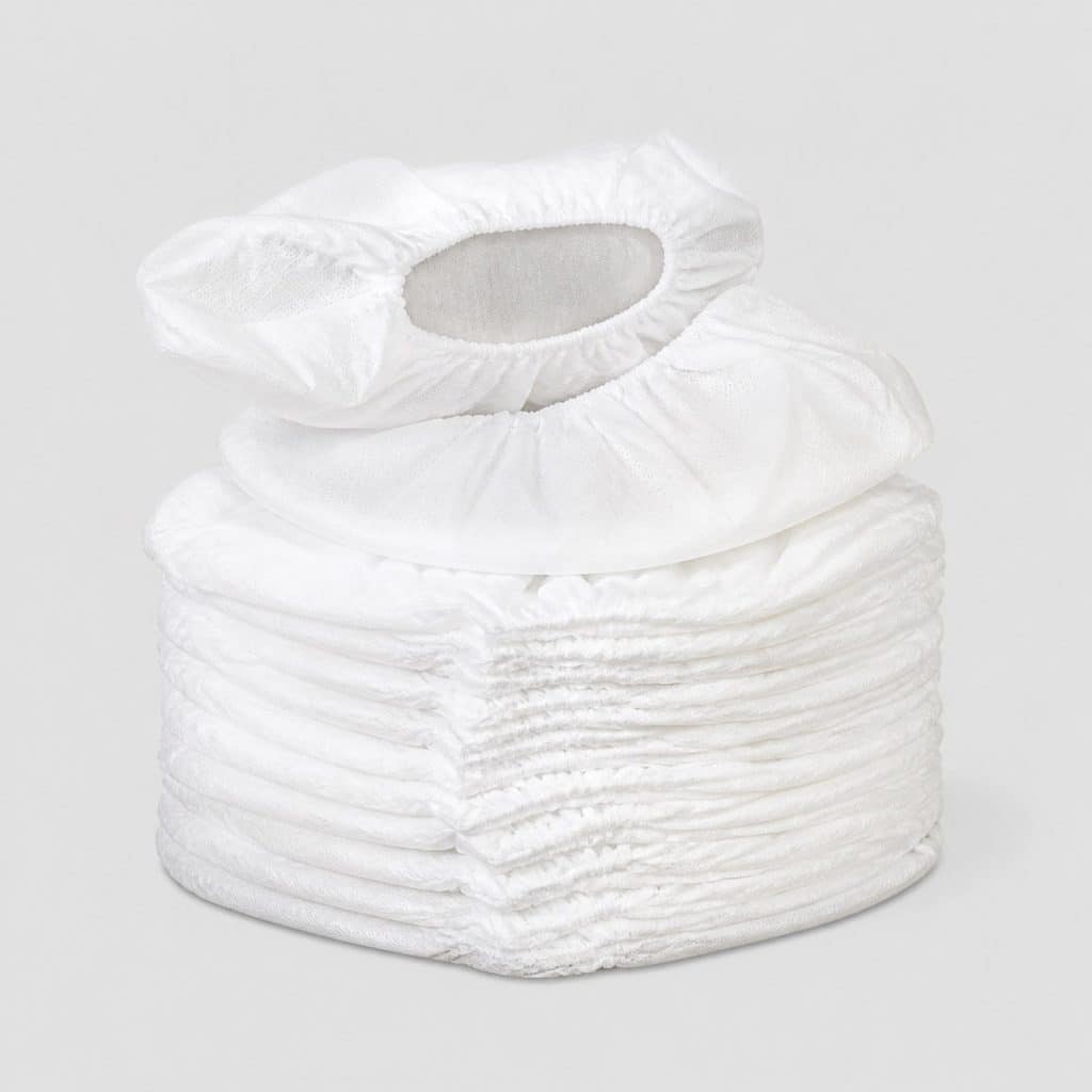 Pile de surchaussures blanches jetables sur fond clair