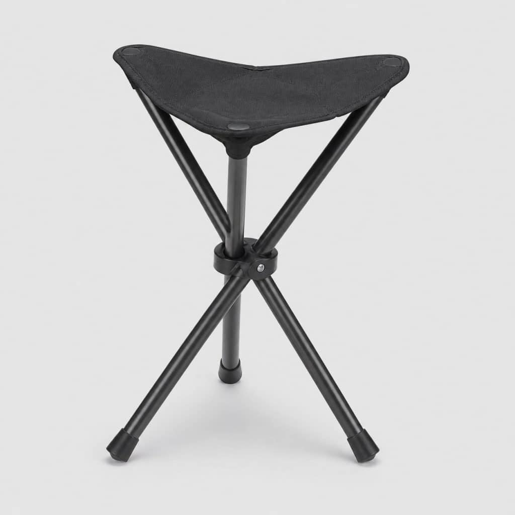 Tabouret pliant à trois pieds en acier sur fond clair