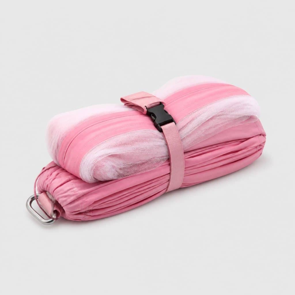 Hamac rose replié avec moustiquaire intégrée sur fond clair